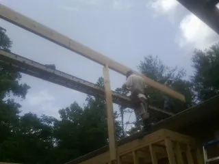 Carpenter setting a ridge beam over a new addition frame — Ice Dam Removal by Roofing Brothers in Cookstown