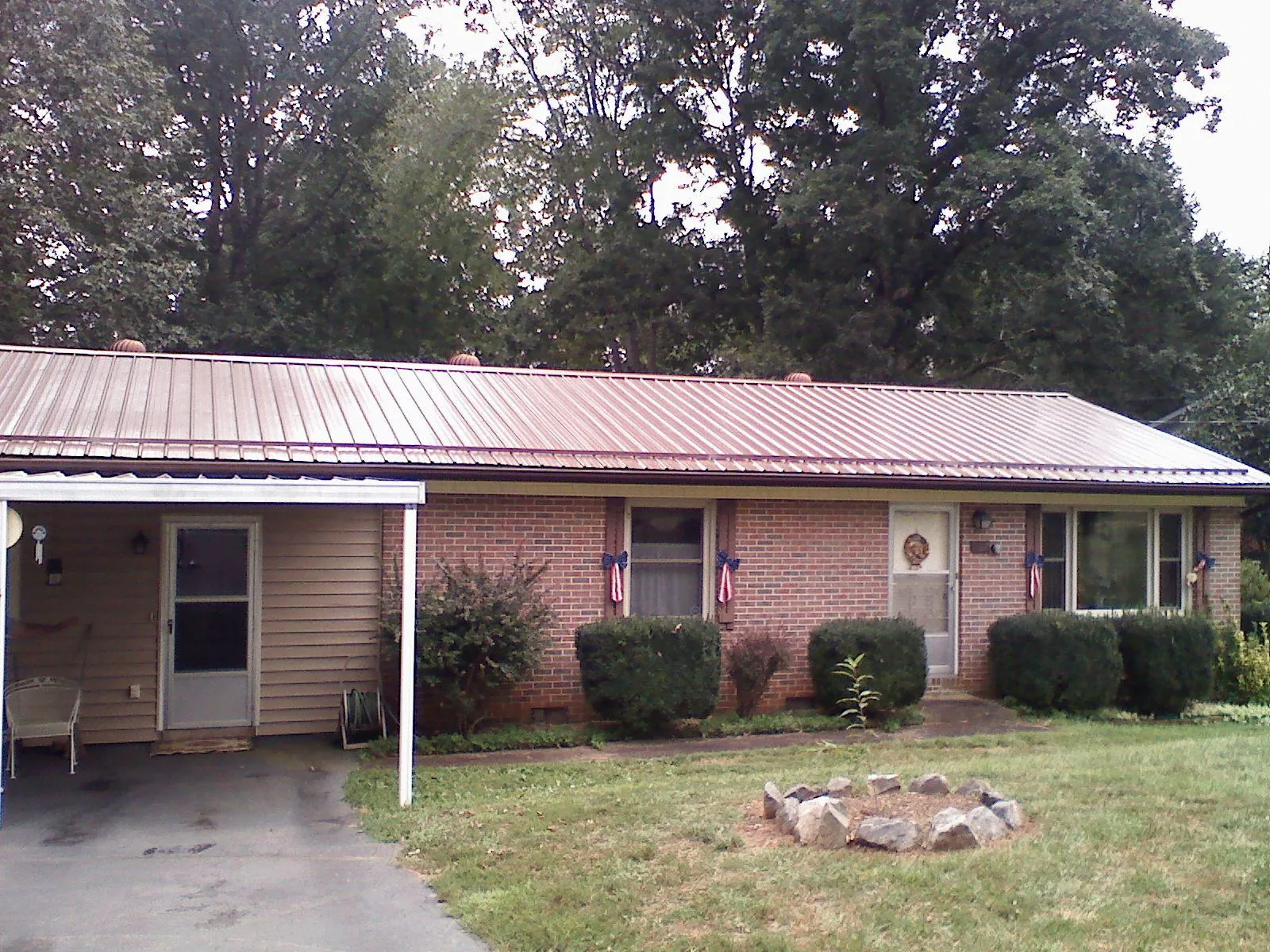 Bronze metal roof and carport on a brick ranch home — Roof Repair work by our crew in Cookstown